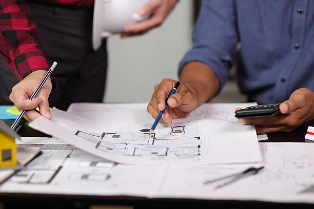 Svart tak med en skorsten och ljusa plankor, takläggning som är pågående.